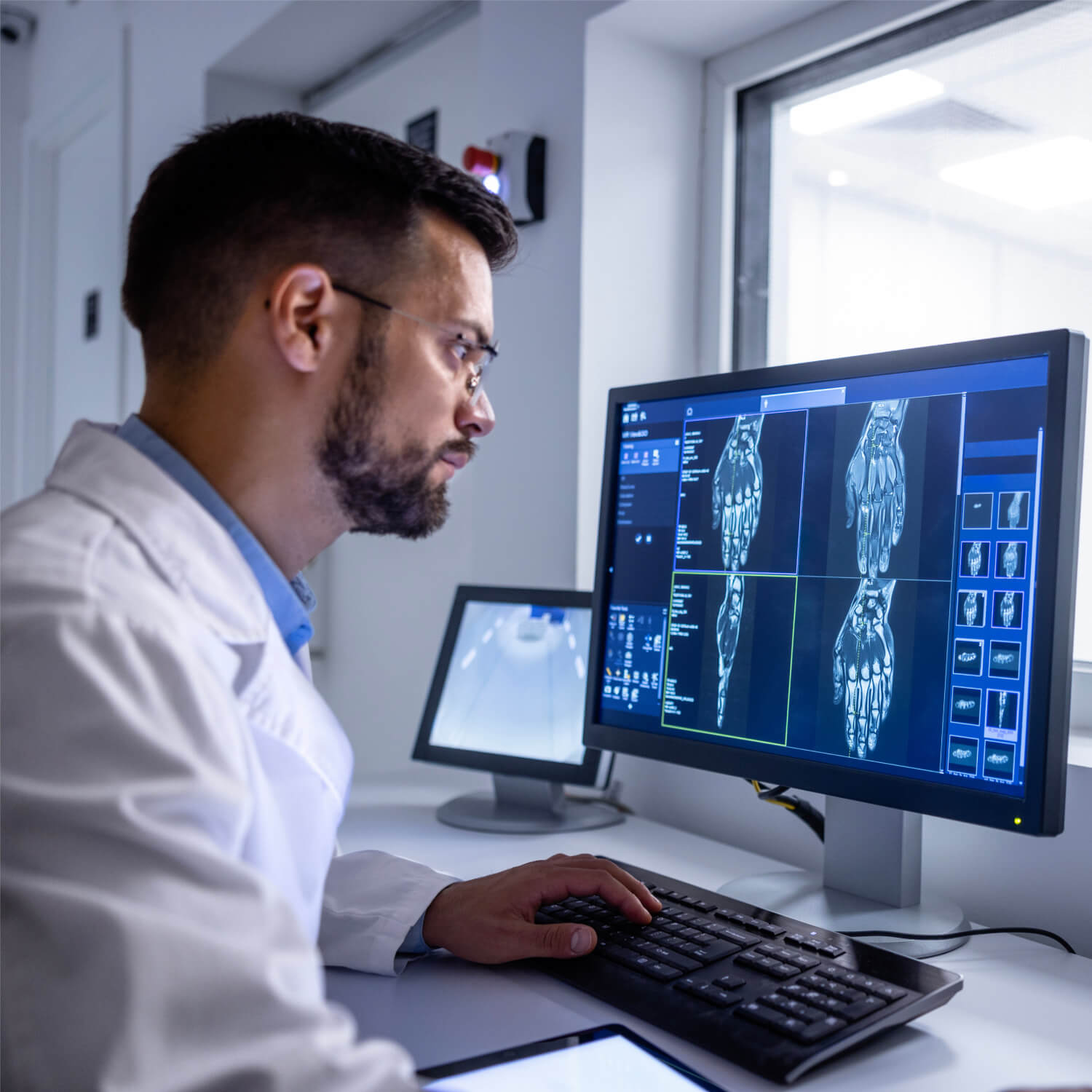 Orthopedic doctor reviewing digital hand and wrist imaging on computer at Knoxville Orthopaedic Clinic
