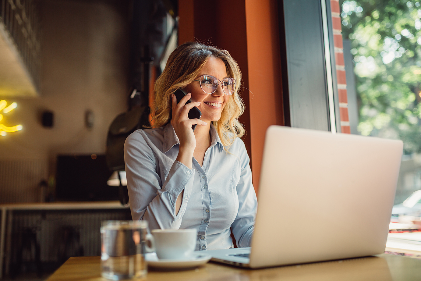 woman with laptop talking on phone